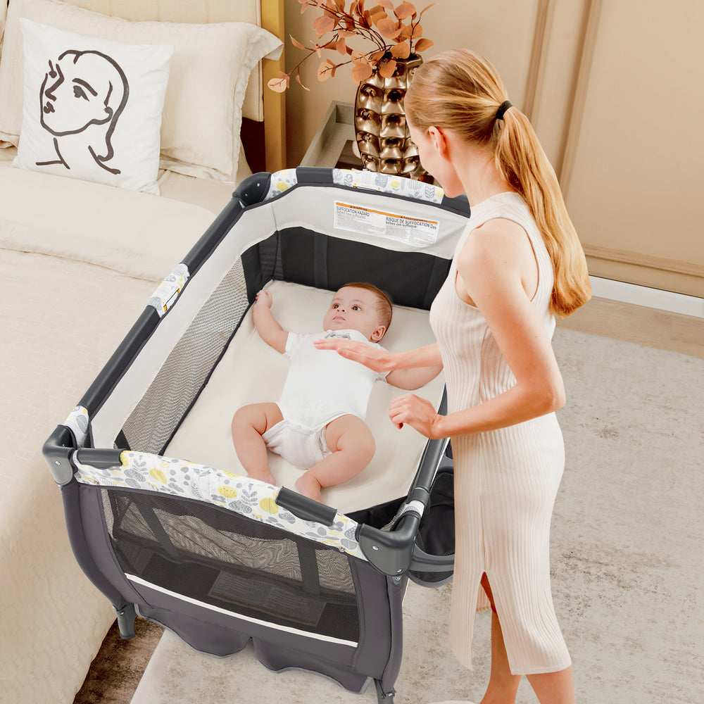 Portable Pack and Play Baby Nursery Center in yellow, featuring a bassinet and changing table, ideal for travel and.