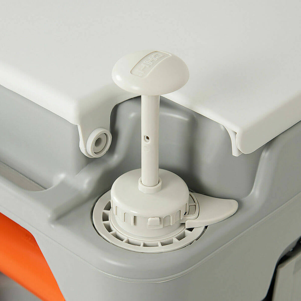 Close-up of the piston pump flush mechanism on a 5.3-gallon portable travel toilet for outdoor use.