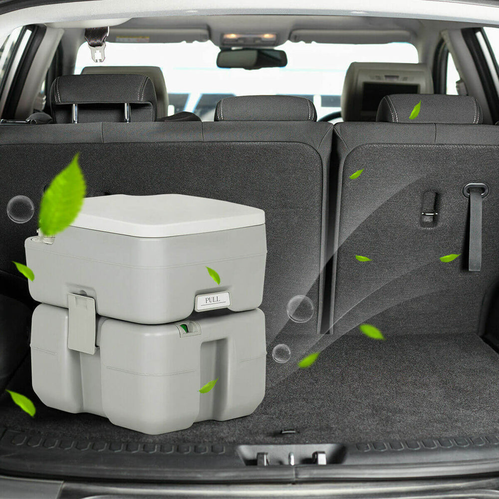 Portable 5.3-gallon travel toilet with piston pump flush, designed for camping and outdoor activities, shown in a car.