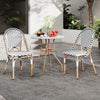 Three-piece French bistro set featuring a round wicker table and two chairs, perfect for outdoor dining.
