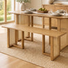 Solid rubber wood dining bench with rattan legs, featuring a natural finish and T-shaped structure for stability.