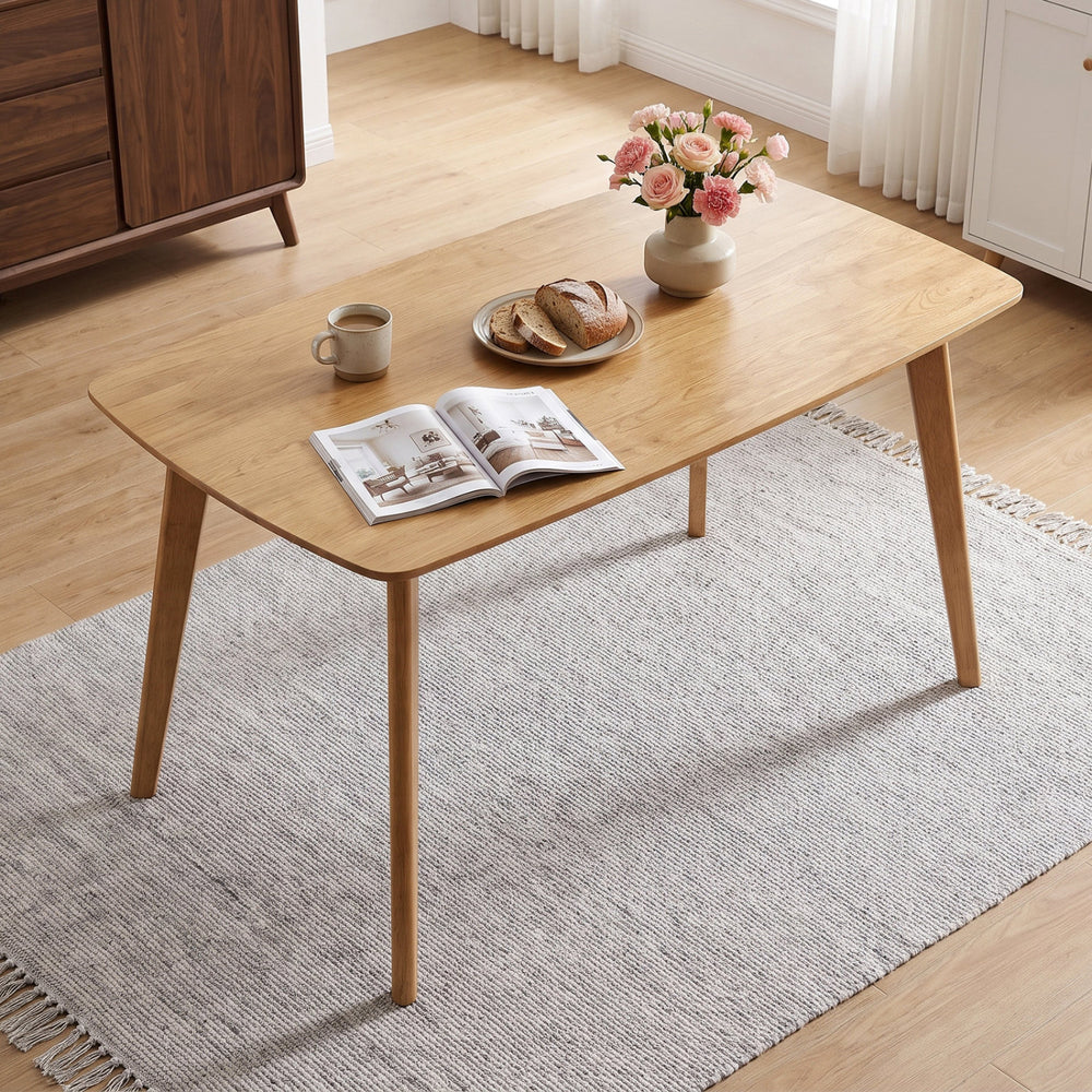 Solid wood dining table with rounded edges, seats 4-6 people, perfect for family gatherings in a natural finish.