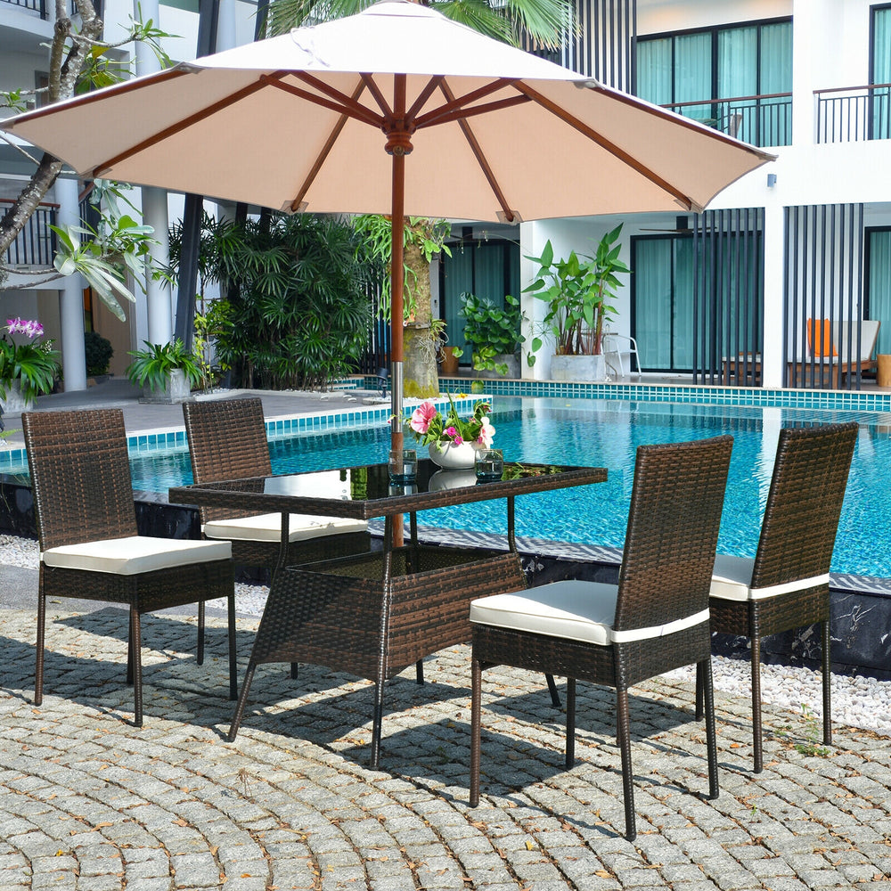 5-piece rattan dining set with glass table and high back chairs, perfect for outdoor dining by the poolside.