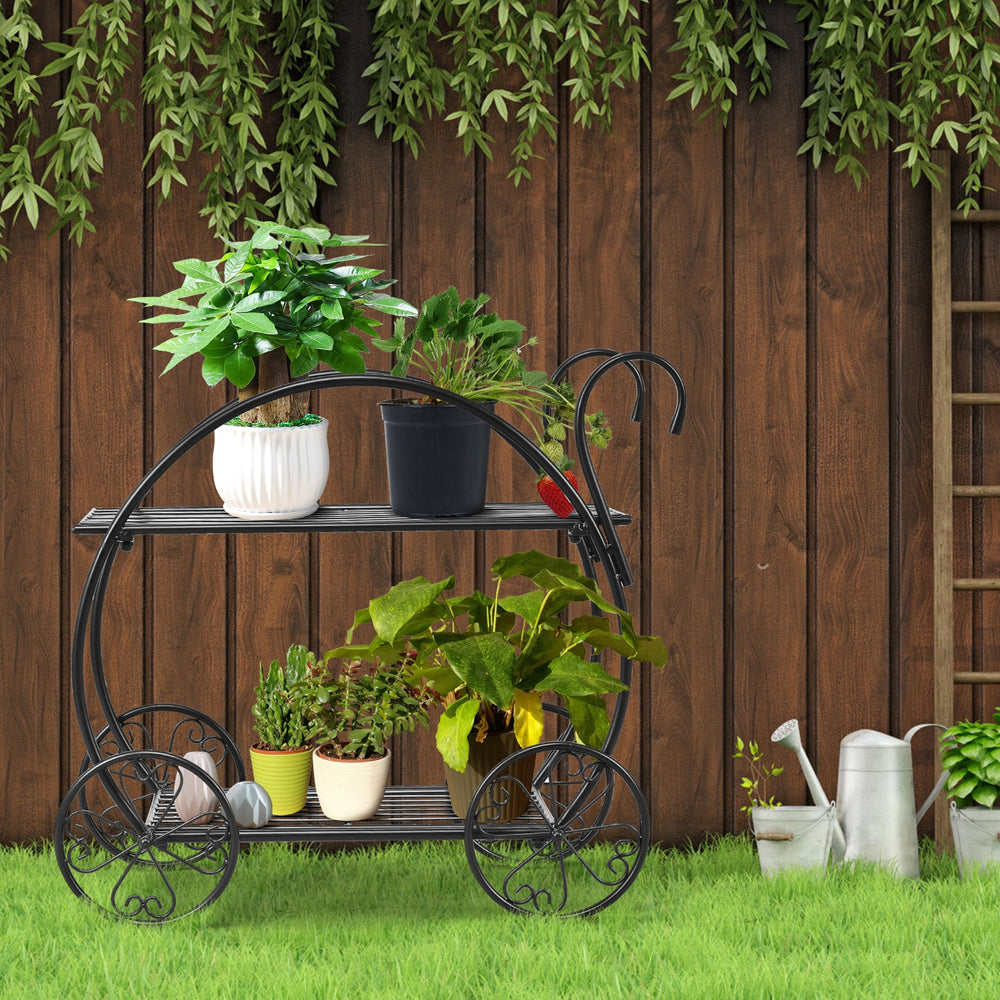 Two-tier heavy duty metal flower cart plant stand with curved handles, displaying potted plants in a garden setting.
