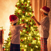 Children decorating a 6 ft PVC artificial Christmas tree with lights and ornaments for festive indoor decoration.