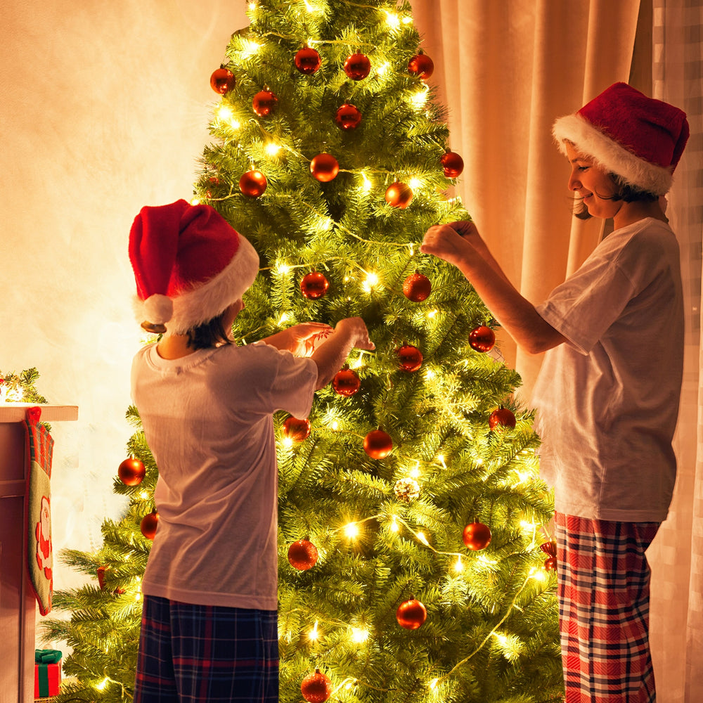 Children decorating a 6 ft PVC artificial Christmas tree with lights and ornaments for festive indoor decoration.