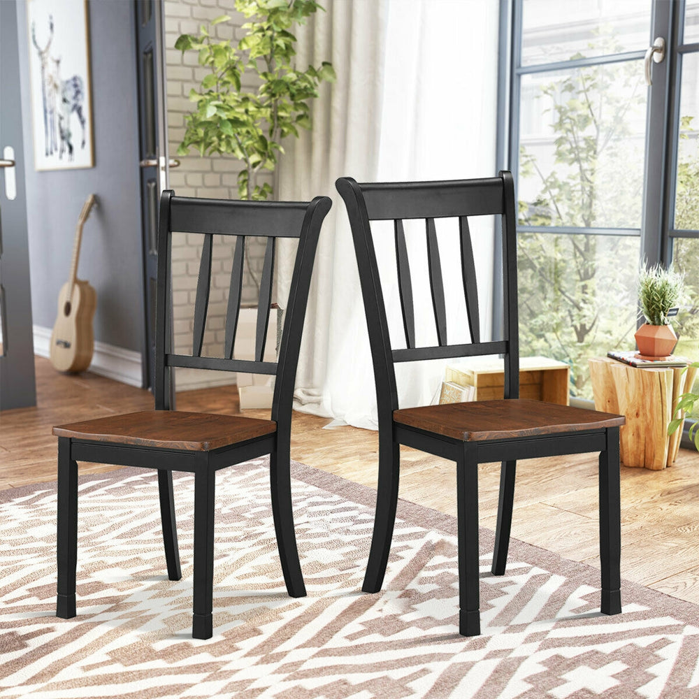 Two solid black spindle back dining chairs made of rubber wood, designed for comfort and stability in any room.