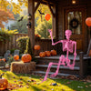 Life-size pink Halloween skeleton with movable joints, sitting on porch steps, perfect for outdoor decorations.