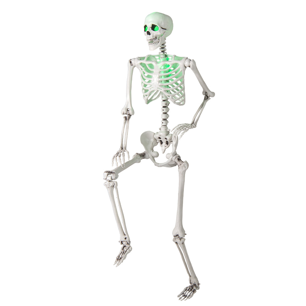 Life-size 5.5 FT Halloween skeleton with posable limbs and glowing green eyes, ideal for creating spooky scenes indoors.