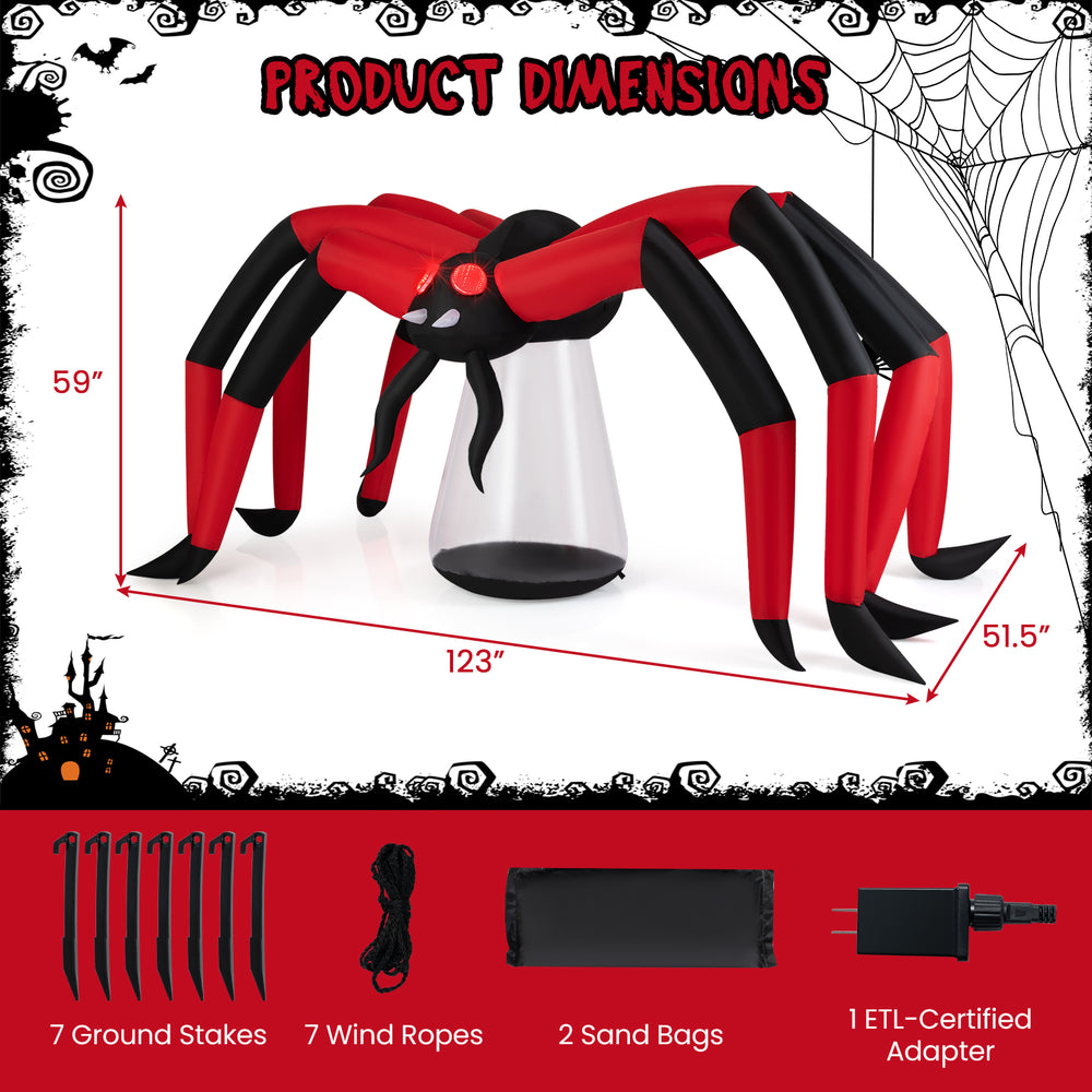 Halloween inflatable spider with red tunnel light eyes, 10-ft span, secured with sandbags and stakes for outdoor use.
