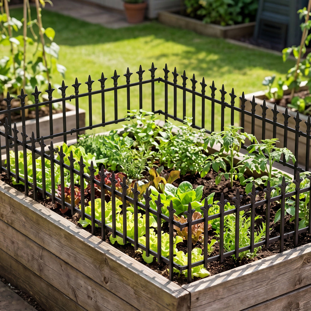 Decorative metal garden fence with fleur-de-lis finials, protecting plants in a raised garden bed for outdoor.