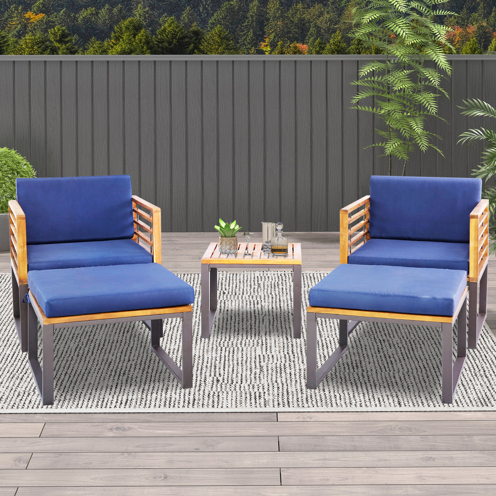 Two navy blue cushioned chairs with acacia wood frames and a coffee table, perfect for backyard or poolside relaxation.
