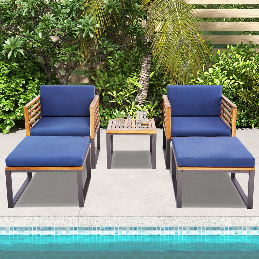 5-piece patio acacia wood chair set with navy cushions, including ottomans and coffee table, ideal for poolside.