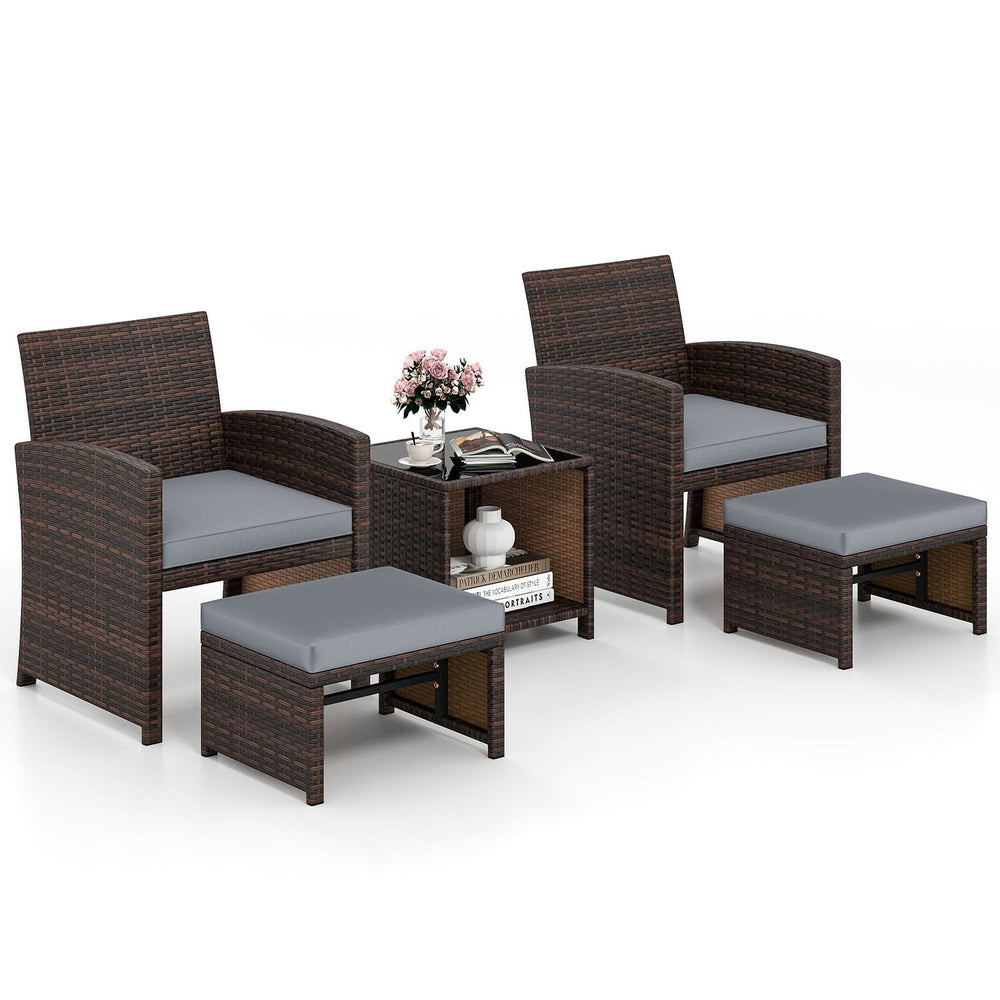 Patio rattan furniture set featuring two chairs, ottoman, and tempered glass coffee table for outdoor relaxation.