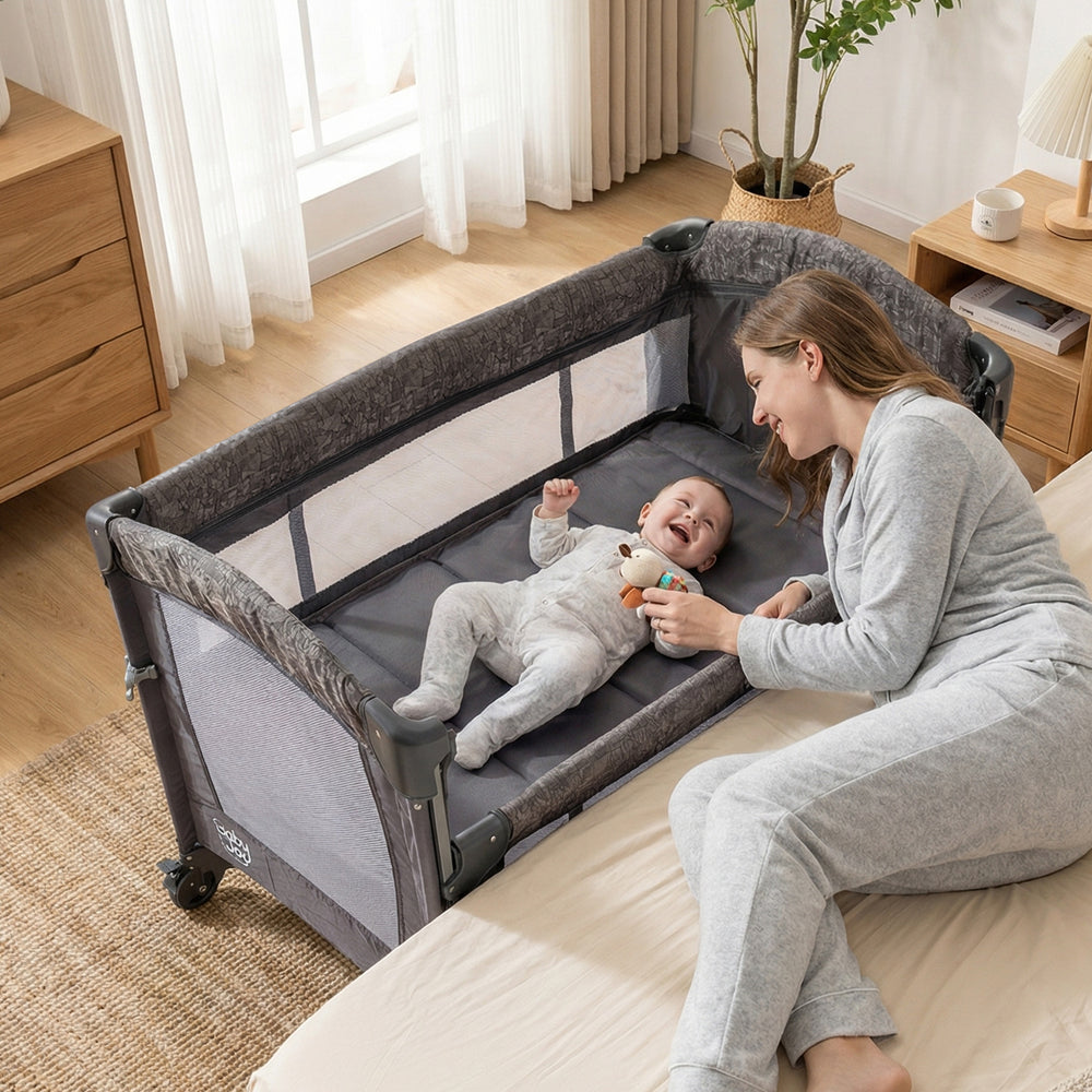 5-in-1 bedside bassinet in gray with adjustable height, mesh panels, and detachable changing table for baby care.