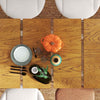 Extendable dining table with bamboo sideboard, plates, and decor, showcasing modern farmhouse style for versatile.