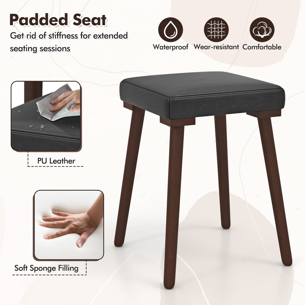 Upholstered stool with padded seat in PU leather and rubber wood legs, perfect for dining or kitchen use.