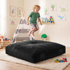 A child joyfully jumps on a 60-inch black crash pad, designed for soft impact absorption and sensory play.