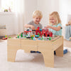 63 Piece Kids Train Table with Storage Drawer and Reversible Tabletop-Natural, shown in use with toy tracks and bridge.
