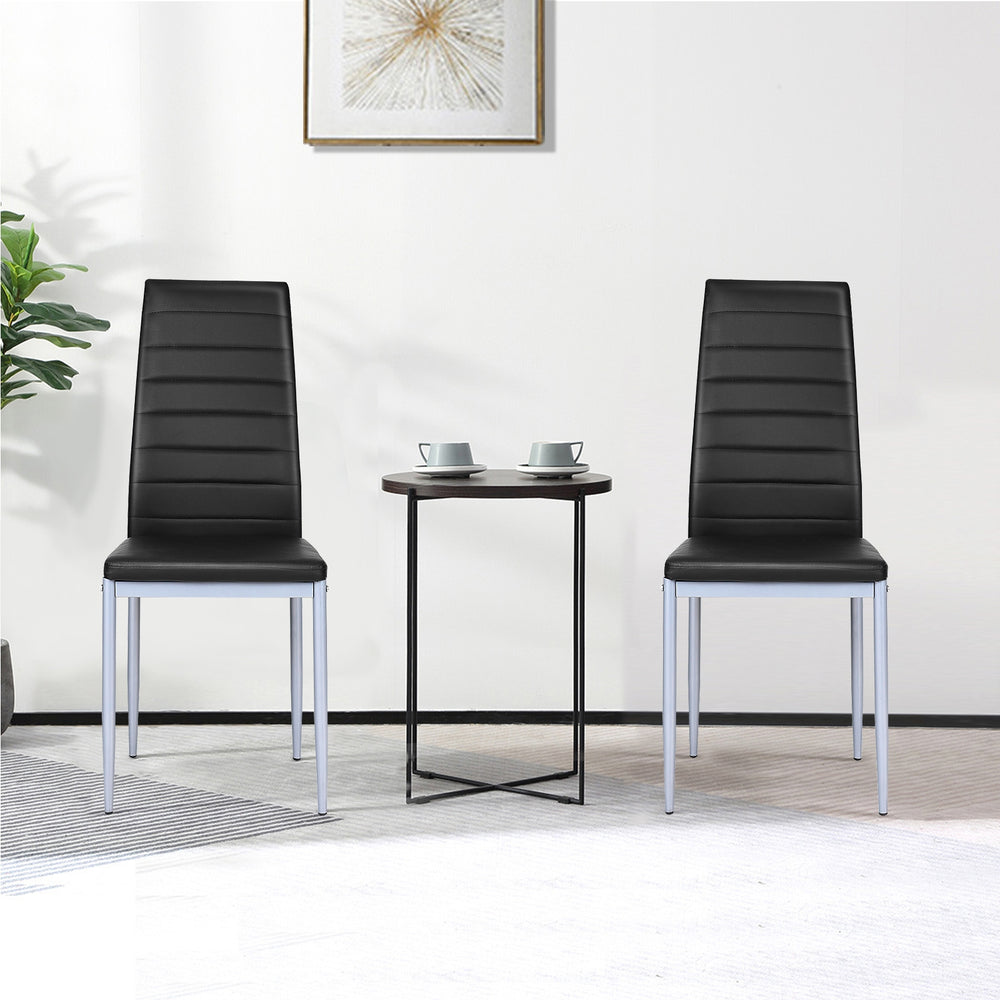 Two elegant black PVC leather dining side chairs with painted steel legs, perfect for modern dining spaces.