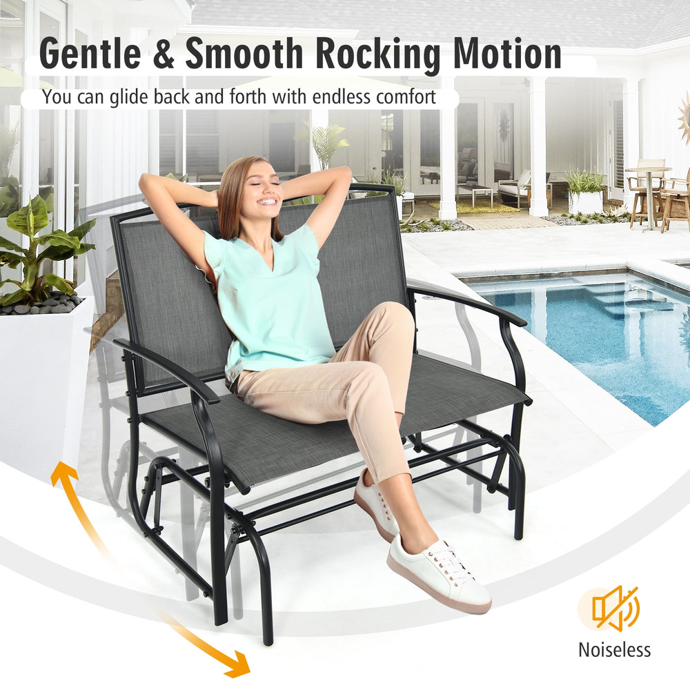 Gray iron patio rocking chair for two, featuring a sturdy metal frame and smooth gliding motion for outdoor relaxation.