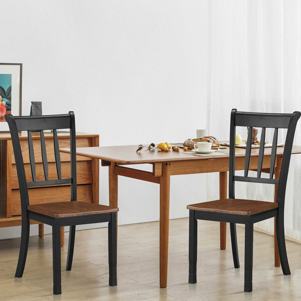 Two solid black spindle back dining chairs made of rubber wood, perfect for dining rooms and kitchens.