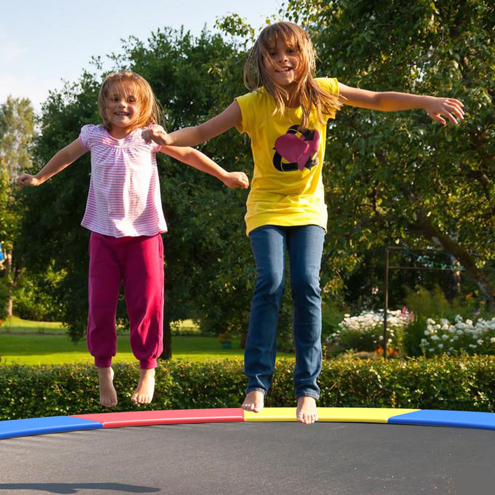 Two girls jumping on an 8 feet trampoline with a multicolor safety cover, featuring thick EPE foam padding for.
