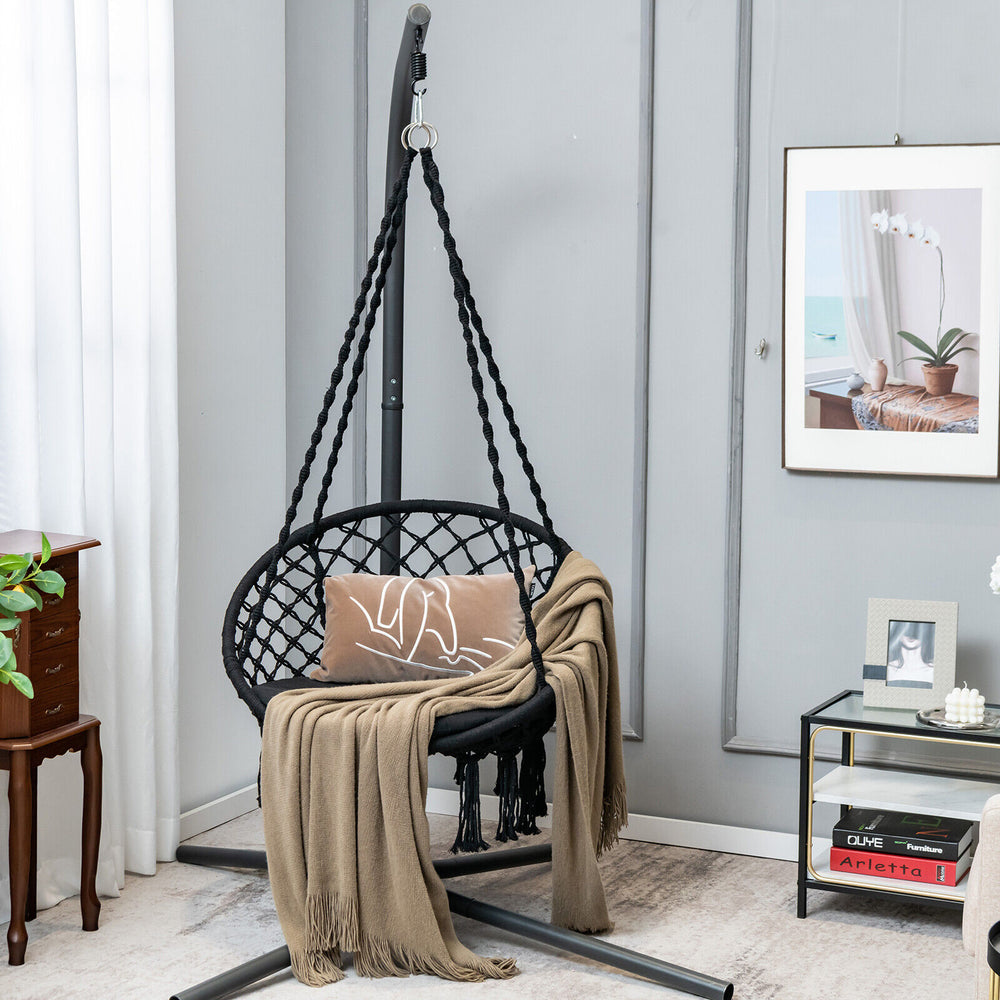 Cushioned black hammock swing chair with inclined backrest and tassels, perfect for indoor or outdoor relaxation.
