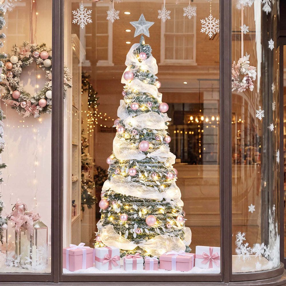 Snow-flocked 6 FT pre-lit Christmas tree adorned with pink ornaments and warm white LED lights for festive decor.