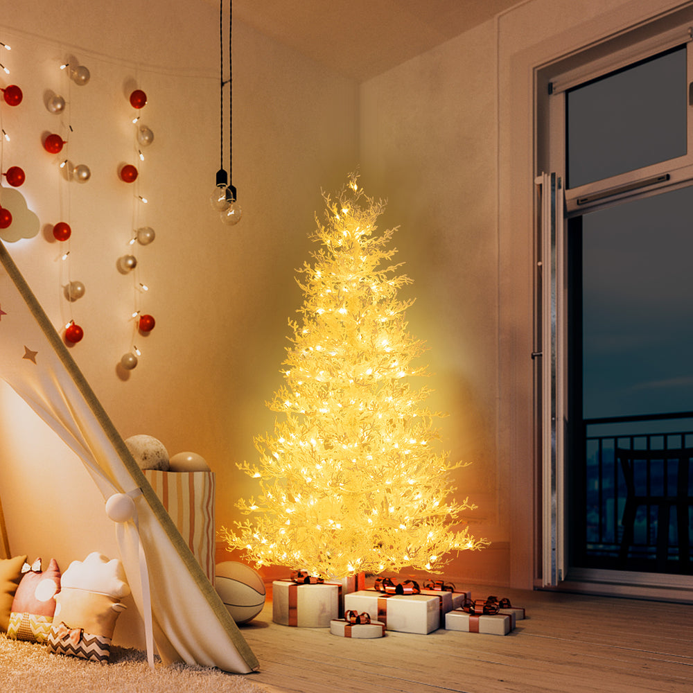 6 feet artificial Xmas tree with 383 PE branch tips and 300 LED lights, glowing warmly in a festive indoor setting.