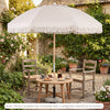 6 feet white patio umbrella with fringe, featuring a wood pole and push button tilt for adjustable shade in a garden.