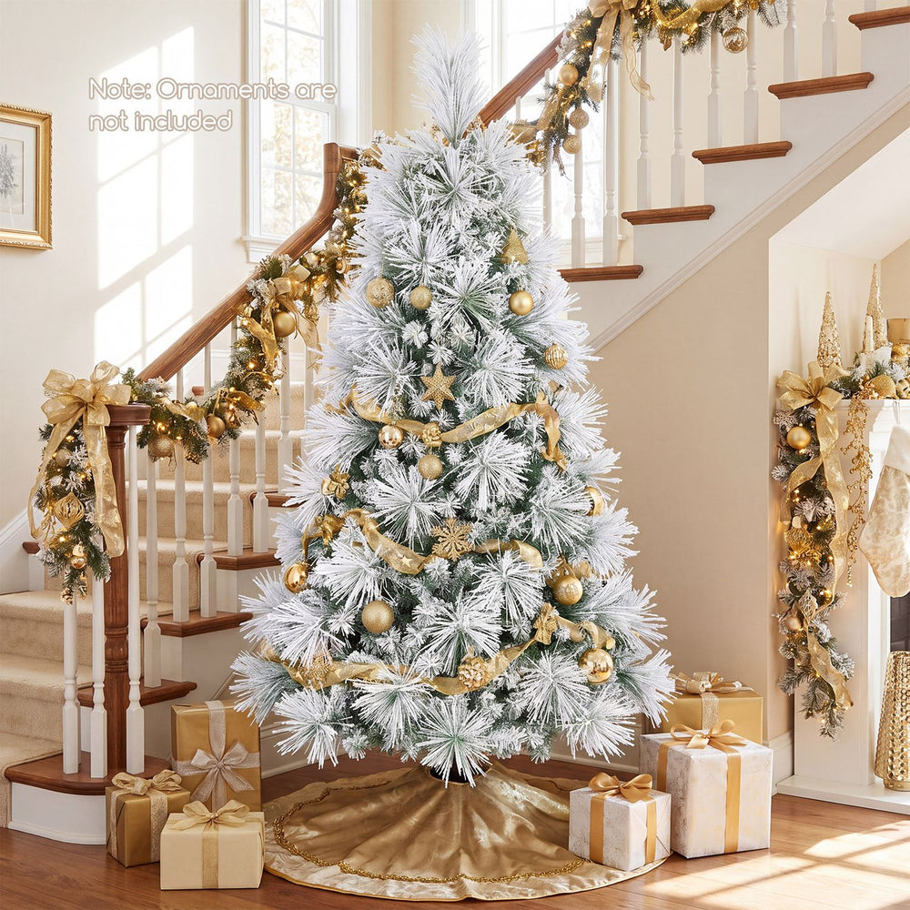 6 ft flocked pine Christmas tree with warm white lights, gold ornaments, and folding metal stand in a festive room.