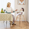 Convertible wooden highchair in light brown with adjustable legs, safety harness, and cozy PU cushion for mealtime.