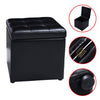 Black foldable cube ottoman pouffe with cushioned top, ideal for storage of toys and accessories.