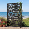 Freestanding 72"H x 48"W black fence panel with hollow-carved design, perfect for enhancing privacy on patios or.