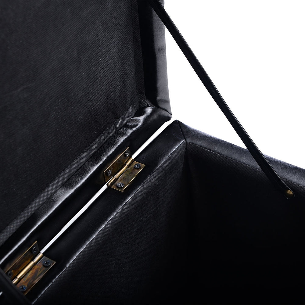 Black faux leather foldable cube ottoman pouffe with cushioned top and hinge design for storage and organization.