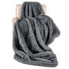 Soft plush gray faux wolf fur blanket draped over a chair, perfect for sofas and beds, offering warmth and luxury.