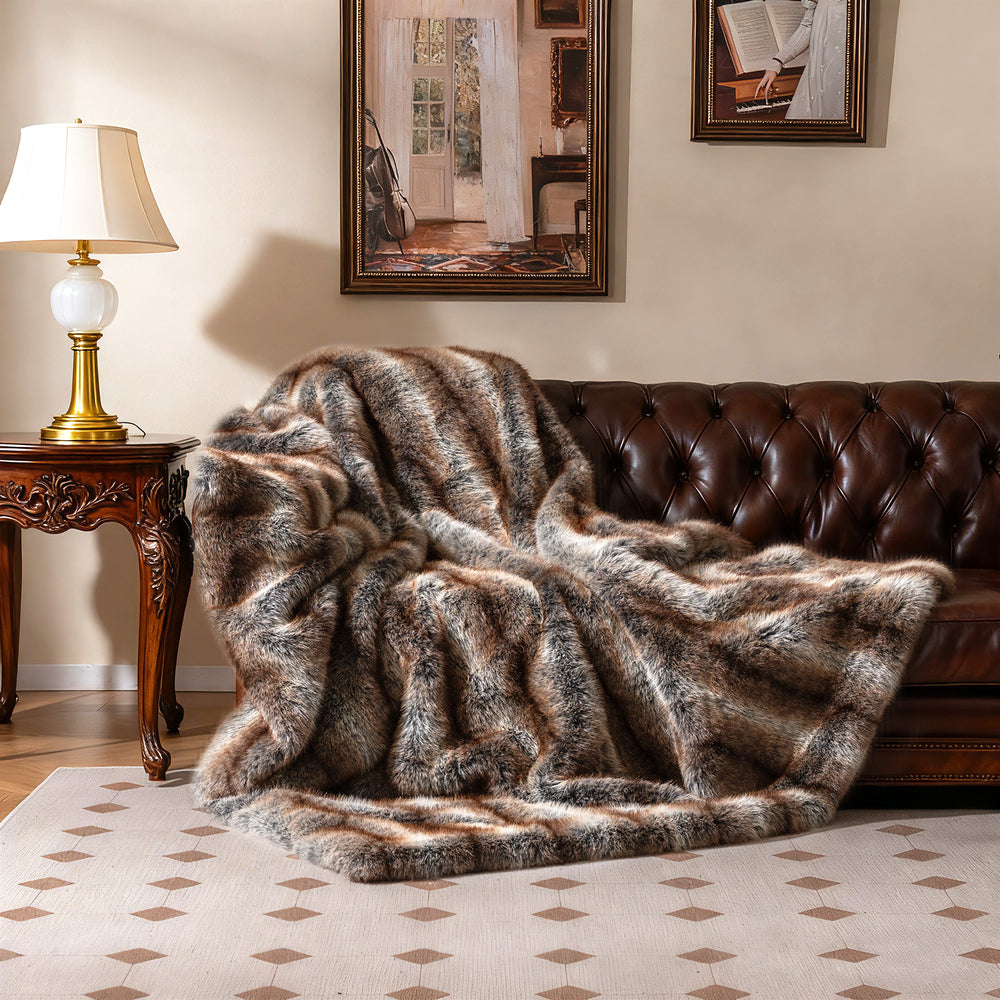 Luxury faux fox fur blanket in brown, featuring a soft plush texture, draped over a leather sofa for cozy warmth.