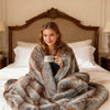 Soft plush fuzzy luxury faux fox fur blanket in brown, draped over a bed, providing warmth and comfort.