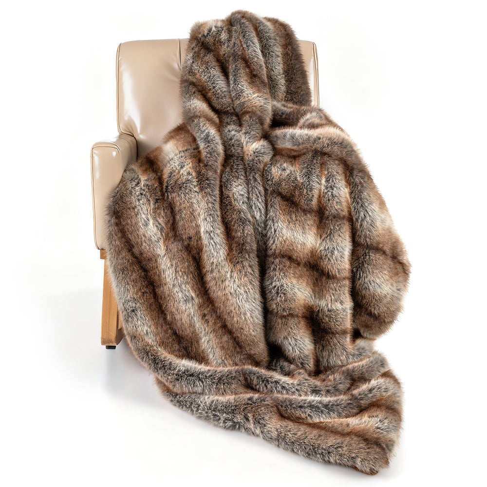 Soft plush luxury faux fox fur blanket in brown draped over a chair, ideal for sofas and cozy relaxation.