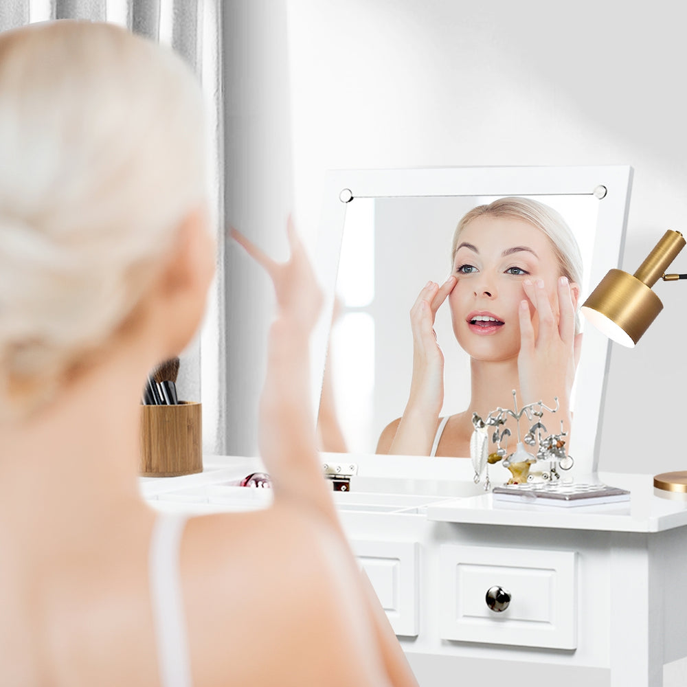 Vanity dressing table set with flip top mirror, showcasing a woman applying makeup, ideal for compact spaces.