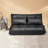 Black foldable PU leather leisure floor sofa bed with two pillows, adjustable for lounging or sleeping in small spaces.