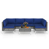 7-piece outdoor furniture set with navy cushions, featuring PE rattan and a tempered glass coffee table for backyard.