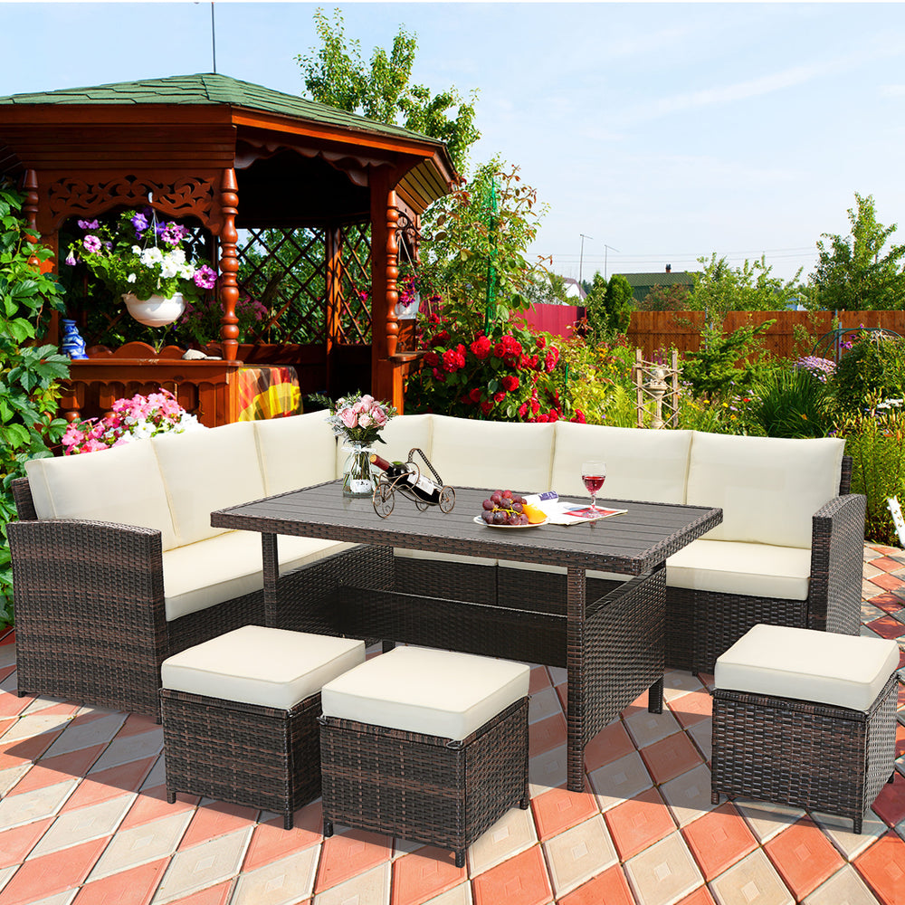 7-piece wicker patio furniture set with white cushions, featuring a wide slatted tabletop for outdoor relaxation.