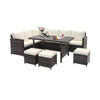 7-piece wicker patio furniture set with cream cushions, featuring a wide slatted tabletop for outdoor relaxation.
