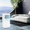 Portable 8000 BTU air conditioner in a modern bedroom, featuring cooling, dehumidifying, and fan modes for versatile.