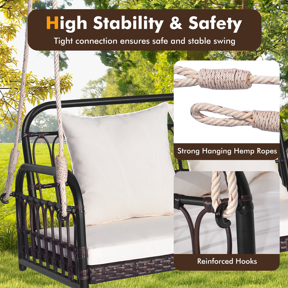 Wicker hanging porch swing with white cushions, featuring strong hemp ropes and reinforced hooks for safety and.