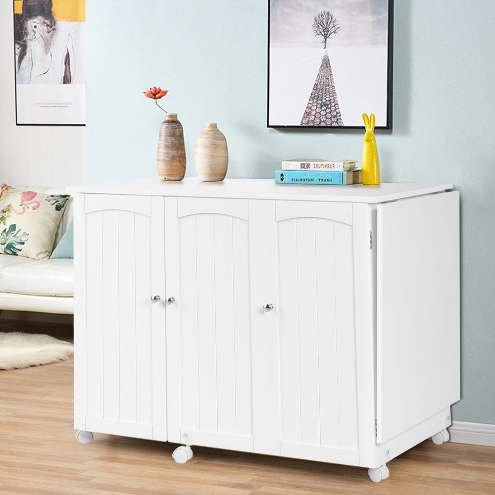 Folding sewing table with wheels in white, featuring three storage bins and an extra shelf for versatile use.
