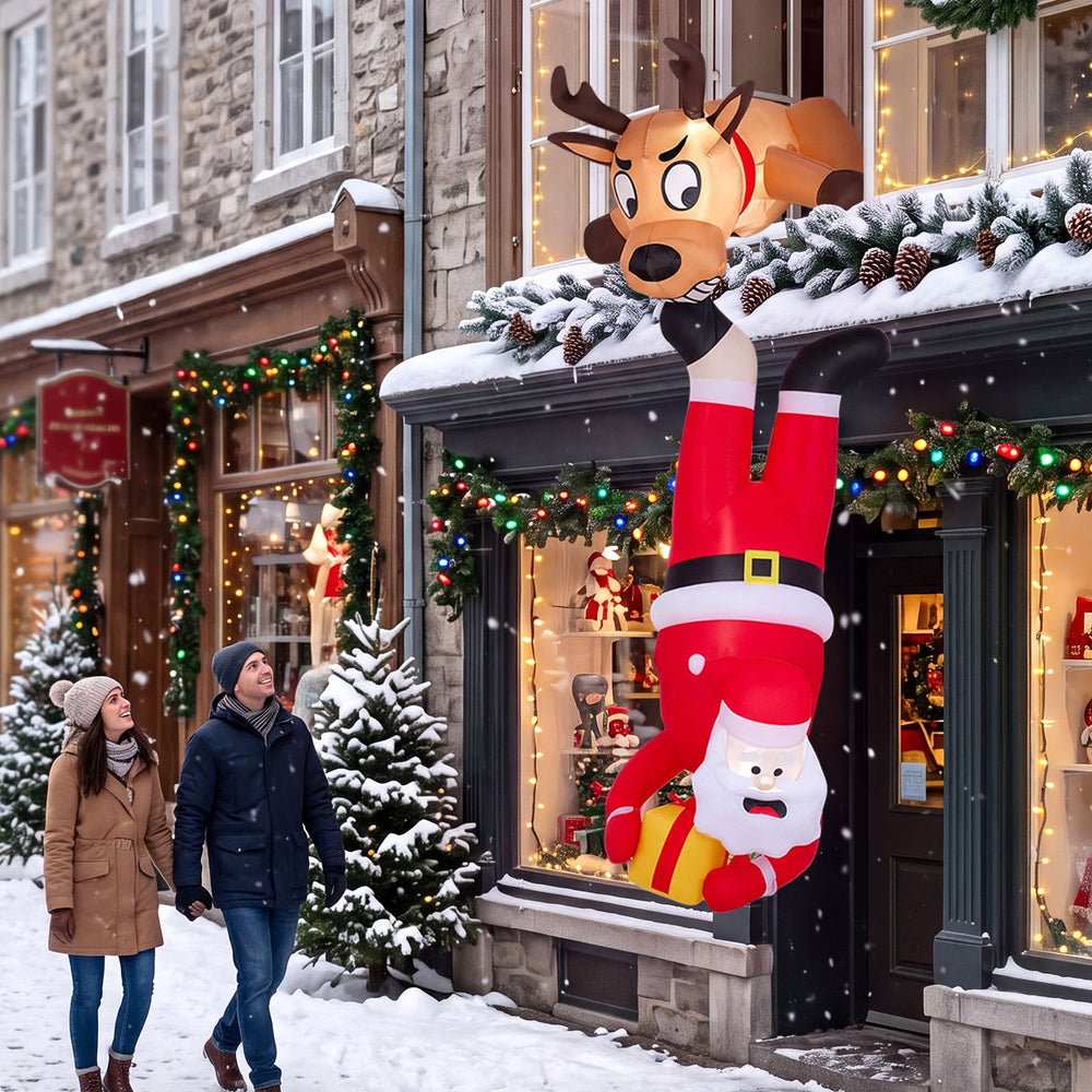 Climbing Santa Claus and reindeer inflatable roof decoration with built-in LED lights for a festive outdoor display.