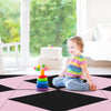 Child playing on a black and pink PU leather folding gymnastics mat, ideal for kids' activities and fitness.